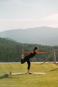 una mujer haciendo una pose de yoga en un campo en The Vinea Collection Hotel by Piamonte Hotels, en Monção