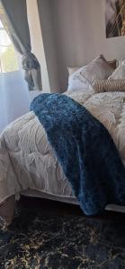 a bed with a blue blanket on top of it at Stylish Bachelor with Oak Floors & View in Johannesburg +17 photos