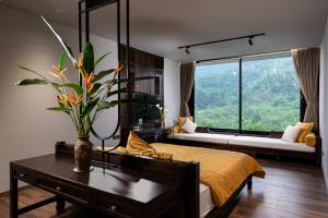 une chambre avec un lit et une grande fenêtre dans l'établissement Đồi Quán Boutique Mansion Ba Vi, à Xóm Trông