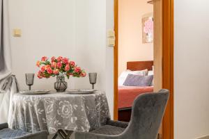 a table with a vase of flowers and two chairs at Panoramio Paleochora Apartments in Palaiochóra +89 photos