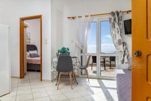 a room with a table and a view of a bedroom at Panoramio Paleochora Apartments in Palaiochóra