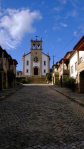 een gebouw met een klokkentoren aan een geplaveide straat bij 9, Cimo da Aldeia in Aldeia de João Pires