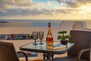 a bottle of wine sitting on a table with two glasses at Panoramio Paleochora Apartments in Palaiochóra