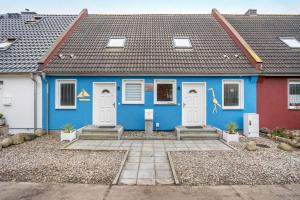 a blue house with white doors and a gray roof at Ostsee in Pruchten
