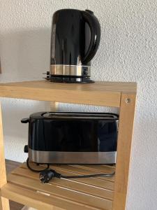 eine Mikrowelle auf einem Holzregal in der Unterkunft Marina et plage à vos pieds in Sète