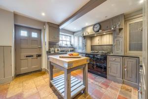 a kitchen with wooden cabinets and a island in it at Garden House in Burnham Market