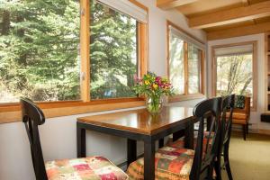 uma sala de jantar com uma mesa com um vaso de flores em RMR: La Choumine 2 Condo in Teton Village em Teton Village