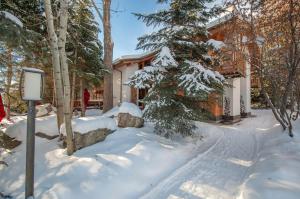 uma casa na neve com árvores cobertas de neve em RMR: La Choumine 2 Condo in Teton Village em Teton Village
