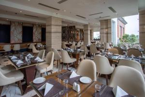 un restaurant avec des tables et des chaises dans une salle dans l'établissement Hotel Lumbini Heritage, à Rummindei