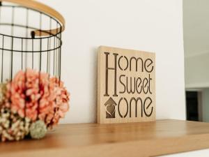 Una flor sobre una mesa con un letrero de "Hogar, dulce hogar". en Home am See - Ferienwohnung, en Wamel