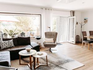 una sala de estar con un sofá y una silla en Home am See - Ferienwohnung, en Wamel