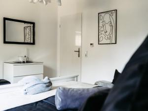 Un dormitorio blanco con una cama y un espejo. en Home am See - Ferienwohnung, en Wamel