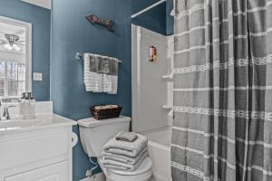 a bathroom with a toilet and a shower curtain at Woodstone Retreat right next to UGA golf course in Athens +14 photos