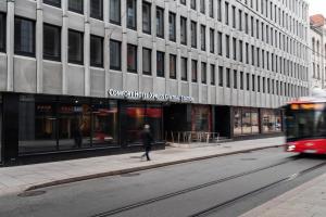 Un hombre caminando por una calle frente a un edificio. en Comfort Hotel Xpress Central Station, en Oslo