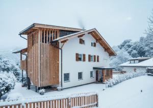 a house in the snow with snow covered trees at Fössing Hof.Apartment in Barbiano