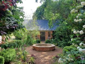 a garden with a fountain in the middle of a yard at Little Fields Country House and Cottages in Howick