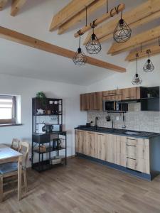 a kitchen with wooden cabinets and a table in a room at Apartmány Pelc in Kořenov