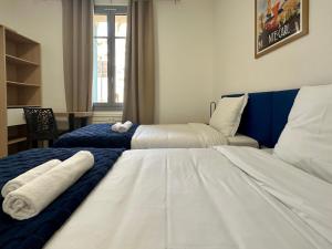 Monaco Villa BRIGITTE Terrasse في بوسولاي: سريرين في غرفة فندق مع مناشف عليهما