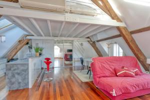 a living room with a red couch and a table at Appartement Aiguillon in Le Croisic