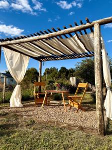 a picnic table and chairs under a white canopy at Casita del Mar Chapadmalal in Colonia Chapadmalal +29 photos