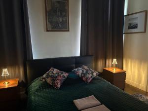 a bedroom with a green bed with two pillows at Apartment Castle Square z widokiem na Plac Zamkowy i Zamek Królewski in Warsaw
