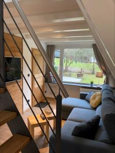Una sala de estar con un sofá y una escalera. en Nurdachhaus Sauerland, en Oberhundem