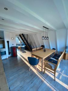 comedor con mesa de madera y sillas azules en Nurdachhaus Sauerland, en Oberhundem 14 fotos más