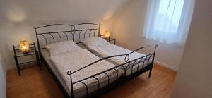 a black bed with two white pillows and a window at Ferienwohnung Alte Scheune in Westerburg