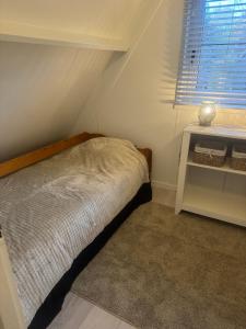 a small bedroom with a bed and a window at Boshuisje Rekem Charly in Lanaken