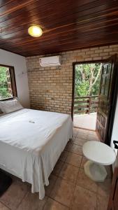 a bedroom with a white bed and a table at Pousada Solar de Maria e Hostel in Baixa de São Francisco