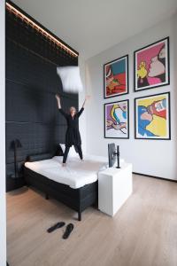 uma pessoa pulando em uma cama em um quarto em Leonardo Hotel Groningen Stadspark em Groningen