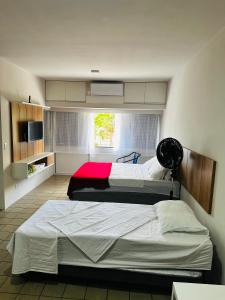 une chambre avec deux lits et une fenêtre dans l'établissement Flat Completo - Praia de Jatiuca, à Maceió 32 autres photos