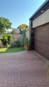 a brick driveway next to a garage at Tana's flat in Brakpan