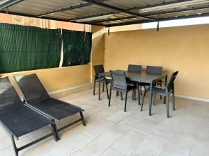 Monaco Villa BRIGITTE Terrasse في بوسولاي: غرفة طعام بها طاولة وكراسي