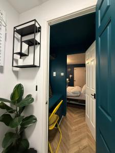 ein kleines Zimmer mit einem Bett und einer blauen Wand in der Unterkunft Studio Flat - Near Oxford Street in Southampton