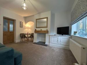 a living room with a television and a table at 2 bedroom cosy home in Nantwich