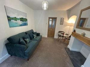 a living room with a blue couch and a table at 2 bedroom cosy home in Nantwich +11 photos