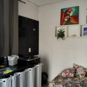 une pièce avec une cuisine, un lit et un comptoir dans l'établissement Estúdio Vênus, à Alto Paraíso de Goiás