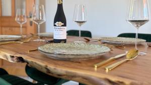 einen Holztisch mit einer Flasche Wein und Gläsern in der Unterkunft Alpendomizil Haberspitz in Marquartstein