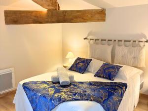 Un dormitorio con una cama con un edredón azul y blanco. en Les Glaneuses gîte Entre Amis centre-bourg à 3 min du Puy duFou, en Les Épesses