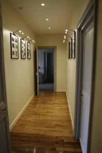 a hallway with wood floors and pictures on the walls at Le Gîte du Bas Manoir in Bretteville-sur-Odon