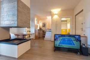 a living room with a tv and a tennis court at Cardarelli Loft Macerata in Macerata