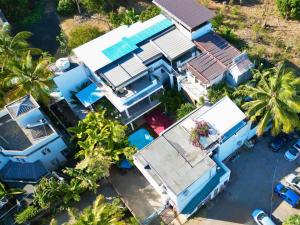 an overhead view of a blue house with palm trees at Villa Alizée - Boutique Hôtel Expérience - Idéal Couples & Pros - Piscine - Restaurant - Rooftop bar - Parking privé - 10min Port-Louis - Ambiance Tropical chic & authentique in Port Louis +55 photos
