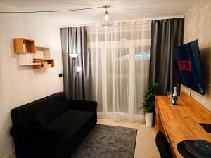 a living room with a black couch and a table at Axiom Suites - Zenith II - Netflix, HBO, Champagne in Košice