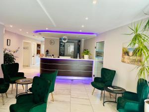 a bar in a waiting room with green chairs at tauwerk Hotel in Wilhelmshaven