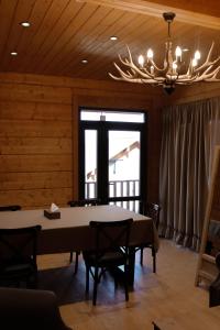 a dining room with a table and chairs and a chandelier at Chalet Myler in Yeghipatrush