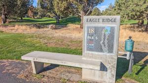 a stone bench sitting in a park with a sign at Red Wing Nest home in Redmond