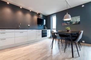 a kitchen with a black table and chairs and a sink at Seaside Apartment in Lofoten - Sea Views in Ballstad
