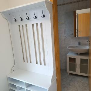 Un baño blanco con un lavabo y un estante blanco. en Domus Limes, RuheOase am Schloss, en Ellingen