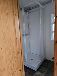 a glass shower stall in a bathroom with a window at Dæli Apartments in Víðidalstunga